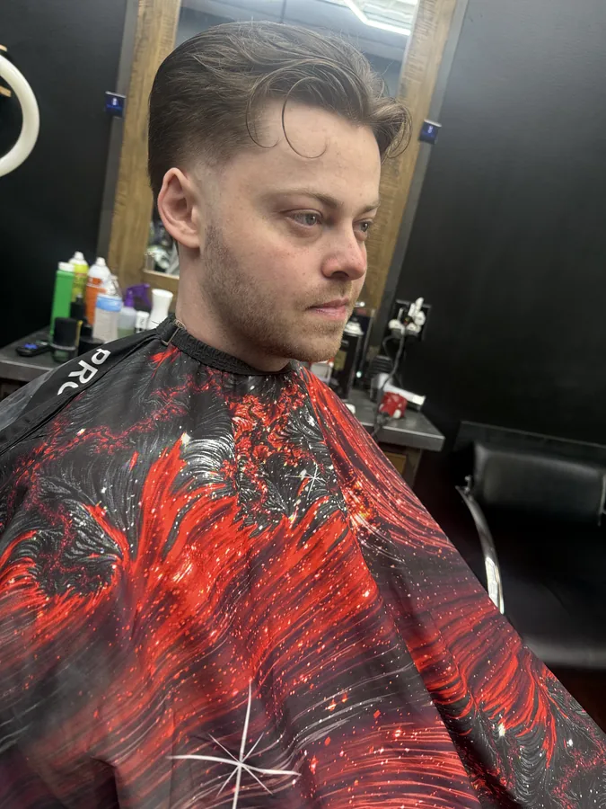 After photo of the same client with a clean tapered cut and a swept-back top
