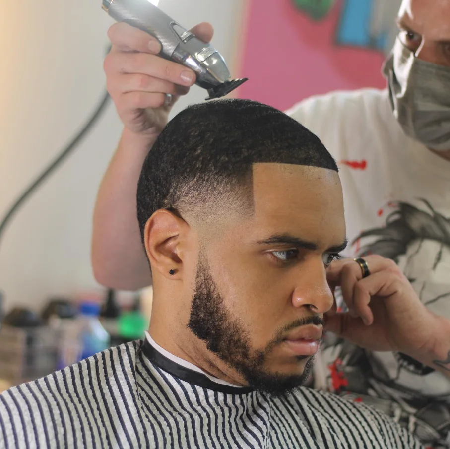 Close-up of Jerm using clippers to shape a client's haircut