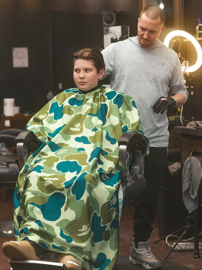 Jerm reading a young client's head before the first pass, ring light behind him